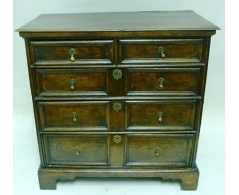 A GEORGE III OAK CHEST, having two short over three long graduated drawers each with moulded front, fitted brass tear drop ha