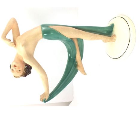 A GERMAN "KATSHUTE" CERAMIC ART DECO FIGURE of a young woman semi clad in a green skirt on circular platform base, factory ma