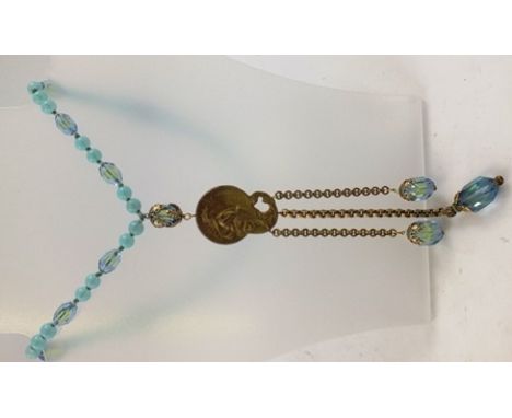 AN ART NOUVEAU SAUTOIR a blue bead necklace suspending a cast pendant with figure decoration and three chains below with blue