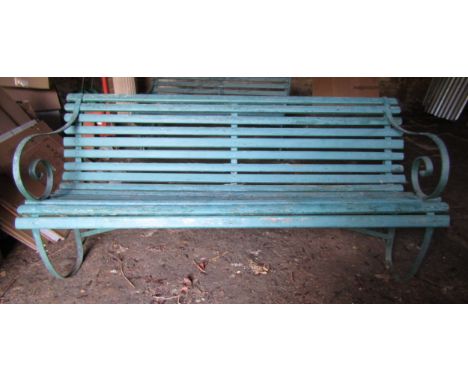 An old garden bench with green painted wooden slatted seat and back raised on sprung steel supports, 180 cm long (af) 