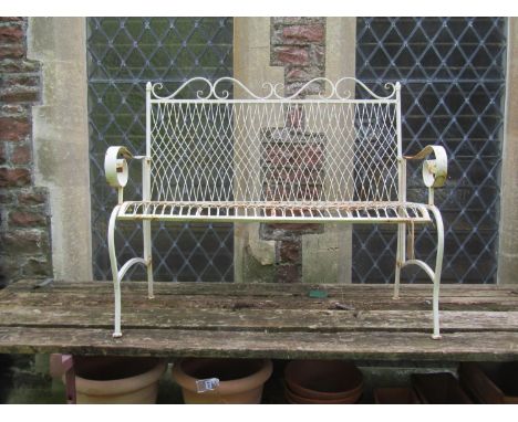 A small decorative weathered cream painted two seat garden folding garden bench with lattice and open scrolled detail, 118 cm