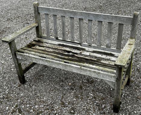 A weathered two seat garden bench with slatted seat and back (unmarked) but possibly a Lister example, 128 cm wide 