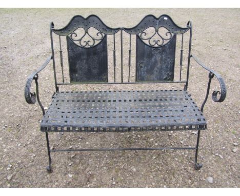 A decorative painted iron work folding two seat garden bench with lattice patterned seat, open scrolled arms and supports, 11