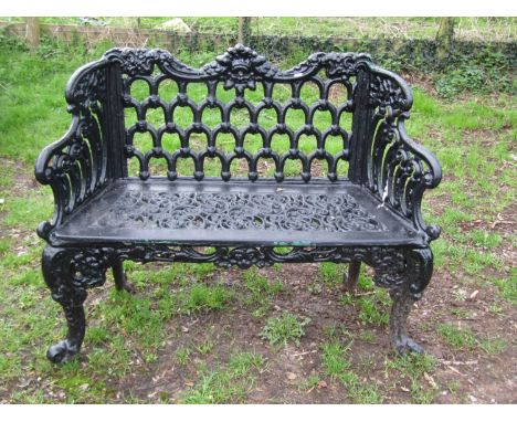 A good quality heavy gauge cast iron two seat garden bench with shaped outline and decorative pierced lattice and scrolling f