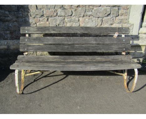 An old unusual garden bench with weathered timber slatted seat and back (able to fold) raised on painted and weathered sprung