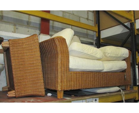 A Wicker two seat conservatory sofa with swept arms and loose seat cushions together with a matching low table loose glass to