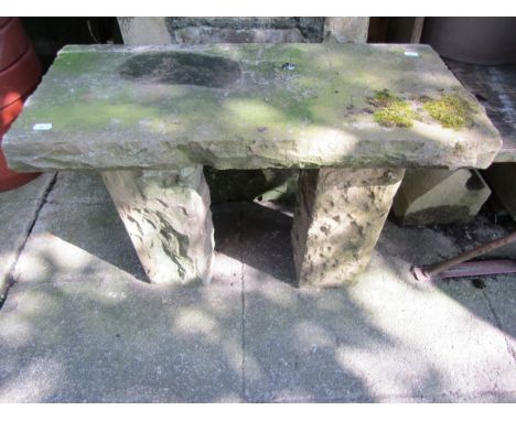 A weathered rough hewn stone garden bench with rectangular slab seat, raised on square cut supports, 52cm high x 72cm x 35cm 