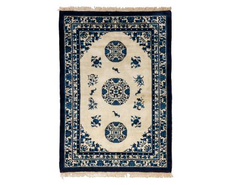 Teppich. CHINA, 20. Jh., ca. 200x136 cm. Der hellbeige Fond des Innenfeldes zeigt drei kreisförmige Blütenornamente, dazwisch