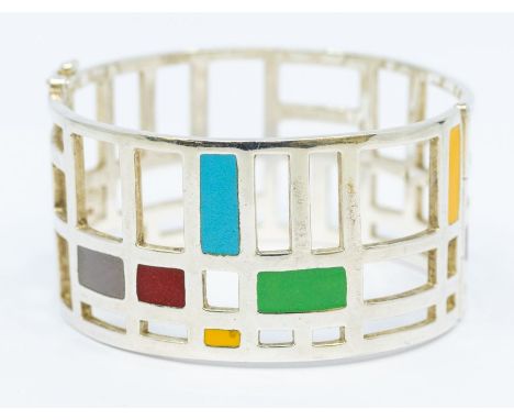 A silver and enamel wide hinged bangle, comprising Mondian style open decoration inset with panels of coloured enamel, width 