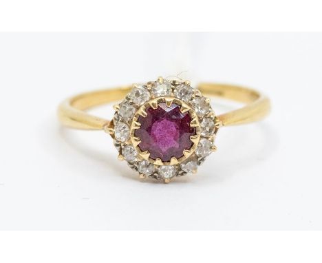 A ruby and diamond 18ct gold cluster ring, comprising a central round cut ruby within a border of diamonds, setting approx 9m