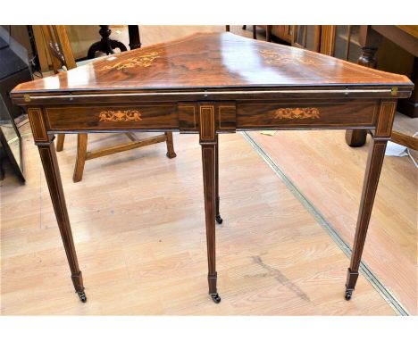 An Edwardian inlaid fold-over card/games table on tapered legs with brown suede playing surface