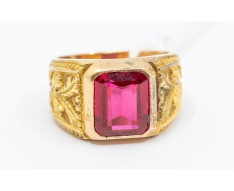 A gents synthetic ruby and 14ct gold ring, comprising an emerald cut synesthetic ruby approx 9 x 11mm, rub over set to a embo