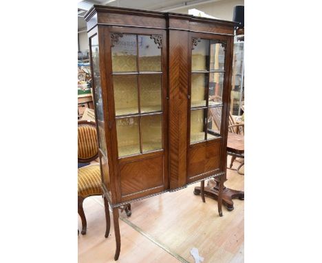 An Edwardian mahogany two door display cabinet having two internal shelves, cross-grain panelling on splayed legs along with 