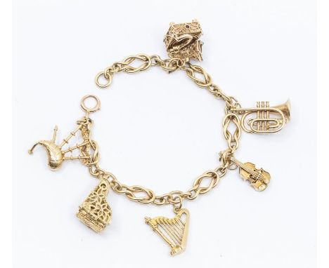 A 9ct gold fancy link charm bracelet complete with six musical themed charms including gramophone gem set, violin, harp, trum
