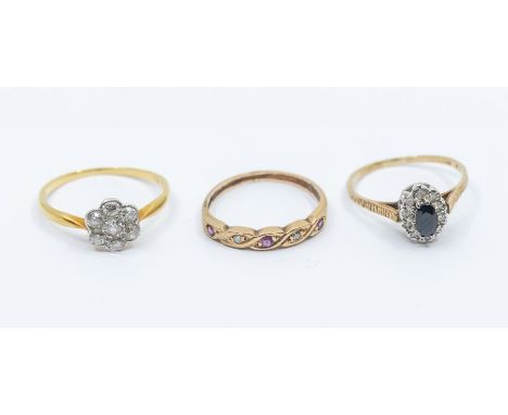 A collection of three stone set rings to include a diamond and 18ct gold cluster ring, a 9ct gold and sapphire set cluster ri