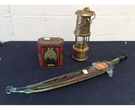 A Brass miners lamp, vintage tin, along with Yakima Brindisi Brandy in sword shaped bottle