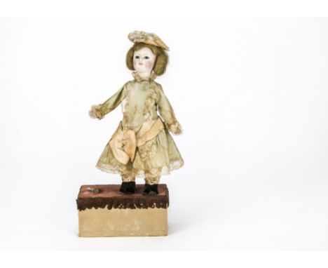 A Reuge child doll automaton, With bisque head, blue glass eyes, blonde wigs, head turning and arm lifting mechanism, dressed