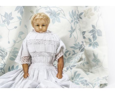 A small Pierotti poured wax baby doll,  With down cast light blue eyes, short inset pale blonde curls, stuffed body with sewn