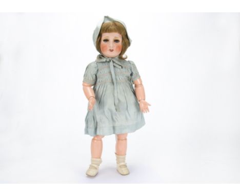 A S.F.B.J. Unis 301 child doll in original condition,  with blue lashed sleeping eyes, light brown hair wig, jointed composit