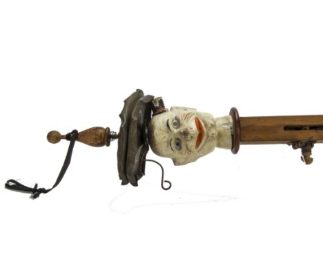 An unusual percussion instrument/one man band,  With painted composition clown head wearing top hat, a long wooden shaft with