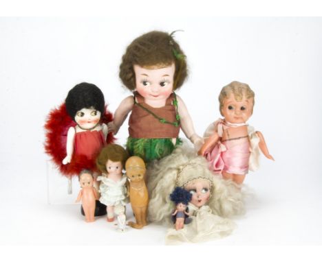 Kewpie-type dolls, A half doll of a kneeling side glancing girl with curled blonde hair —2in. (5cm.) high, three plaster Kewp