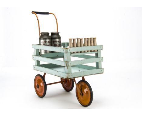 A Tri-ang milk float, painted light blue wood with red metal wheels, two tinplate milk churns and wooden milk bottles —19in. 