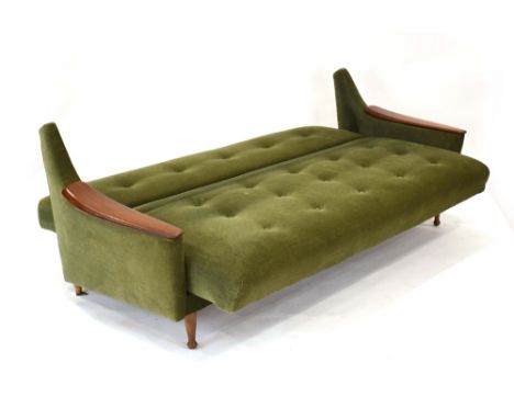 Attributed to Guy Rogers of Liverpool, a 1960's green button upholstered 'click-clack' sofa bed with teak arms and spindle le