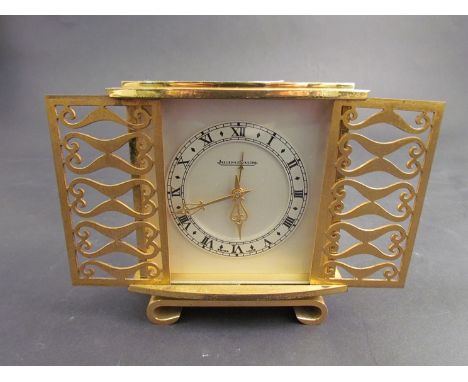 A Jaeger Le Coultre brass desk alarm clock with pierced gilt sliding doors