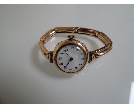 A 9ct gold lady's wristwatch, white enamel dial with red twelve 