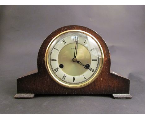 A Smiths compact oak cased striking mantel clock with balance escapement, key 