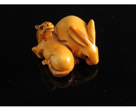 A Japanese ivory netsuke - horse and hare. Signed.