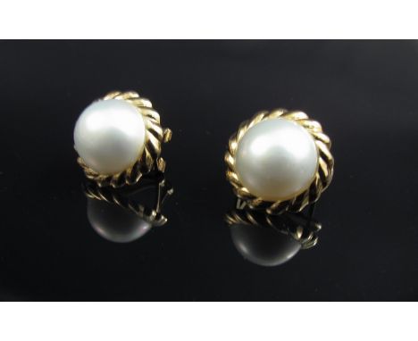A pair of 9ct gold earrings as simulated pearl studs with gold rope detail surround 