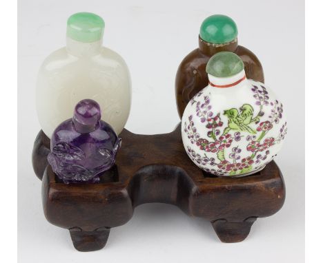 FOUR SNUFF BOTTLES WITH STANDGroup of four Chinese snuff bottles, each ovoid in shape and between 1 3/4" and 2 3/4"tall. One 