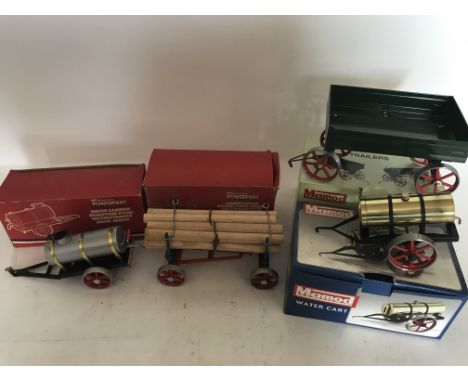 A collection of boxed trailers, including Mamod traction engine trailer, Mamod water cart, Powerpart water carrrier and a pow