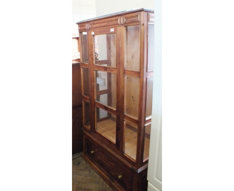 A stained Pine single door display cabinet with plate glass shelves