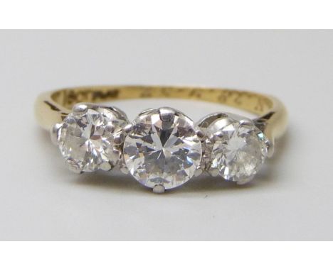 An 18ct gold and platinum set three stone diamond ring, inner shank engraved, 2.4g, K