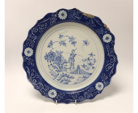 An 18th century Lambeth delftware charger, 34cm in diameterThree chipped areas between 12 o’clock and 3 o’clock as shown; a p