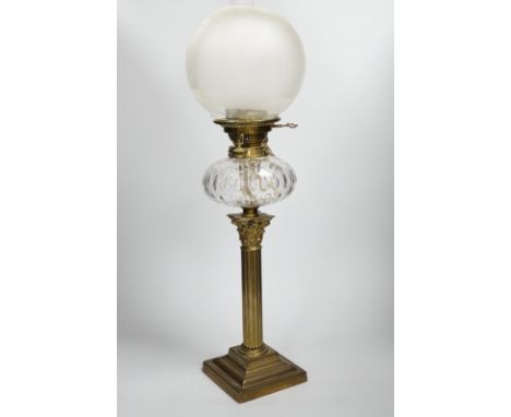 A Victorian brass oil lamp with glass reservoir and etched shade, 70cm high