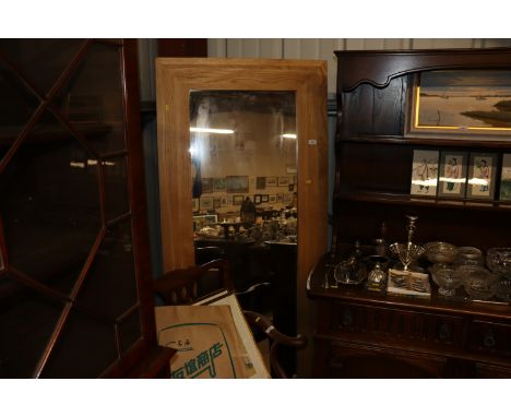 A large light oak framed wall mirror 