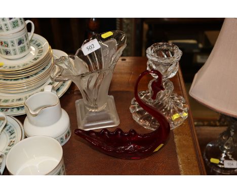 A Baccarat glass candle stick; a frosted glass posy vase and a Venetian style red glass swan ornament