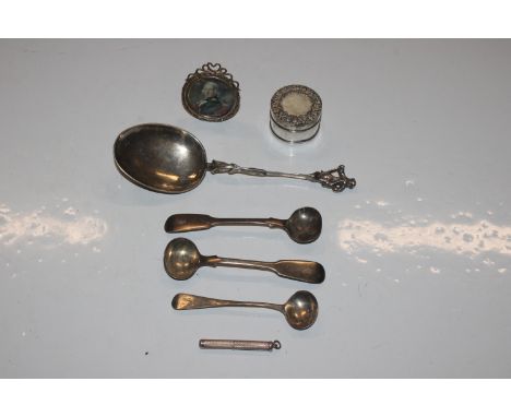 A white metal spoon with figural decoration to the terminal; three silver cruet spoons; a silver and mother of pearl decorate