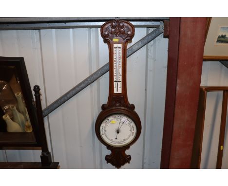A carved oak banjo aneroid barometer/thermometer