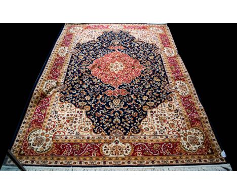 A Large Woven Silk Carpet Keshan carpet on blue ground with navy, red, ochre and cream repeated floral and foliate design. Br