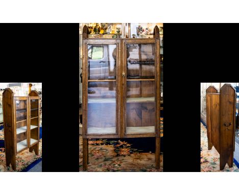 An Arts & Crafts Golden Oak Display Cabinet. Three shelf cabinet with glazed doors and brass pull handle. Chamferd studded fi