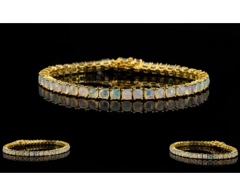 Opal Tennis Bracelet, a line of cushion cut opals, totalling 10cts, set in 14ct gold vermeil and silver, fastening with a ton