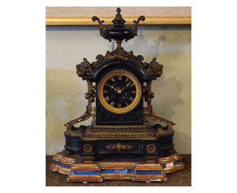 Victorian cast brass mounted black slate cased mantel clock, the elaborate mounts with mask head decoration, conforming black