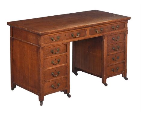 A 19th century Gothic revival oak desk, c.1880, with an arrangement of ten drawers around a kneehole, bears retailers label f
