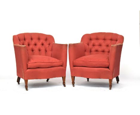 A pair of early 20th century deep button upholstered country house armchairs, each with feather filled cushion, on square tap