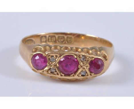 An 18ct gold, ruby and diamond ring, arranged as three round cut rubies, the largest weighing approx 0.25 carats, the rubies 