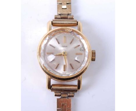 An 18ct yellow gold lady's Tudor manual wind wristwatch, having round silver baton dial and fitted to a 9ct yellow gold three